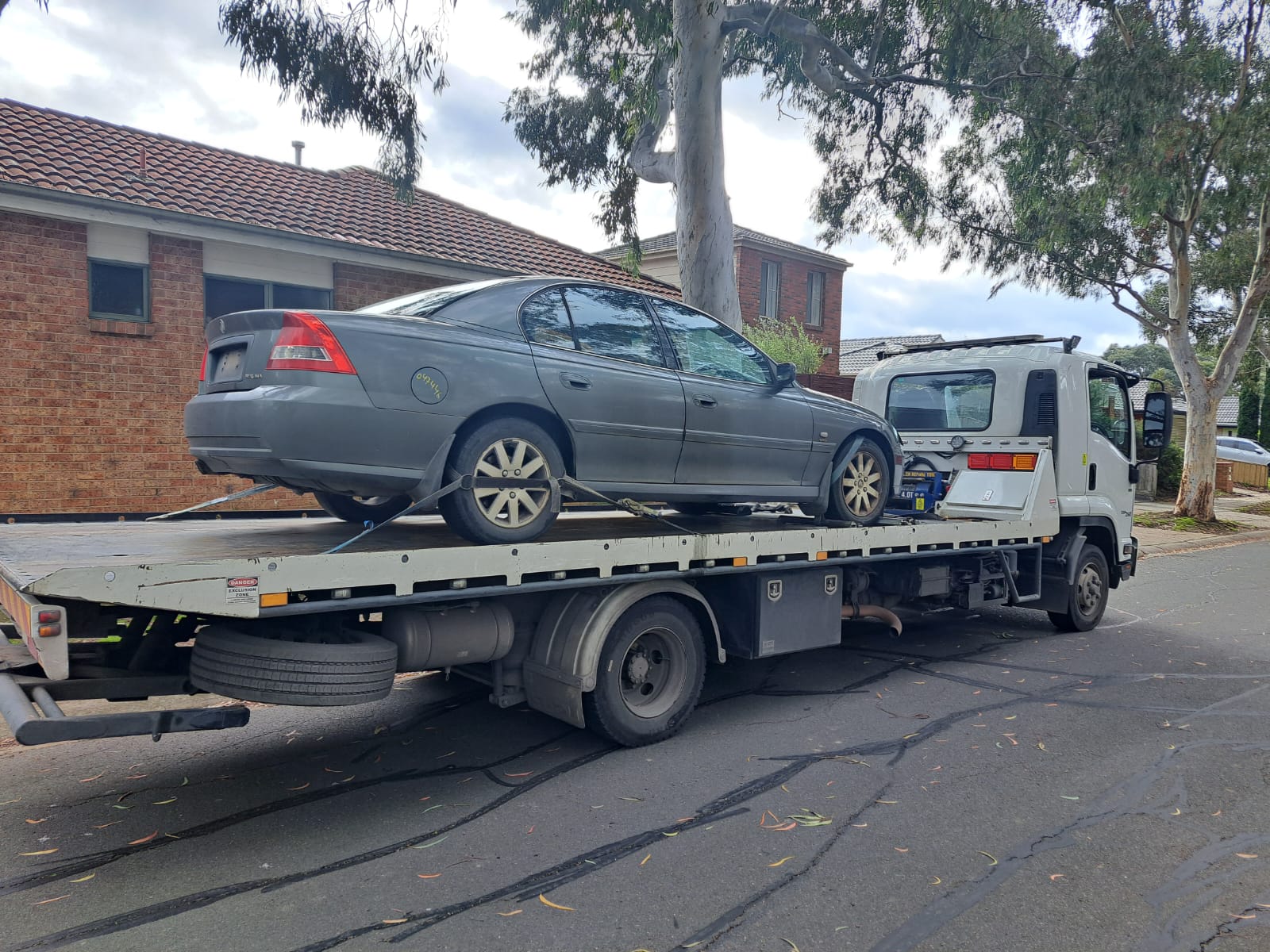 Unwanted car removal Melbourne with sedan loaded on tow truck